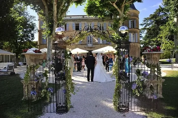 Une cérémonie devant le château, sous l’arche de fer forgé