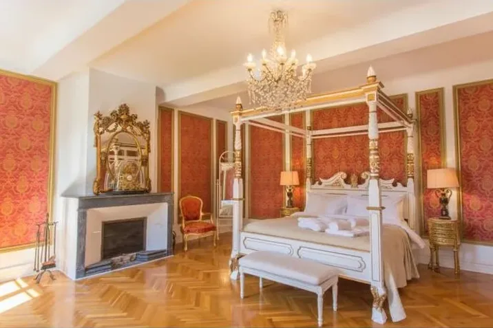 Une chambre du château : lit à baldaquin et murs tendus de damas